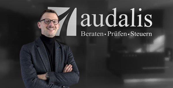 Christian Michel vor Wand mit audalis-Logo